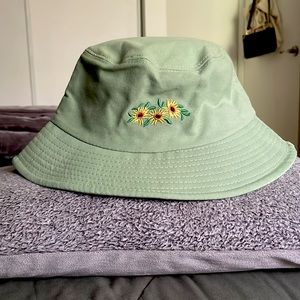 One-size fits most green bucket hat with sunflower embroidery.